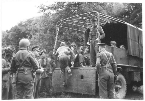 THE BRITISH ARMY IN NORTH-WEST EUROPE 1944-1945 - German prisoners of 21 Panzer Grenadier Regiment, getting into a lorry to be taken down to base outside Longueval by 5 Commandos British Army, 21st Army Group
